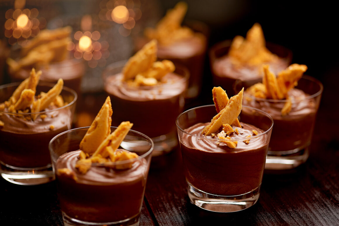 group shot of small single serve chocolate mousses with honeycomb garnish.