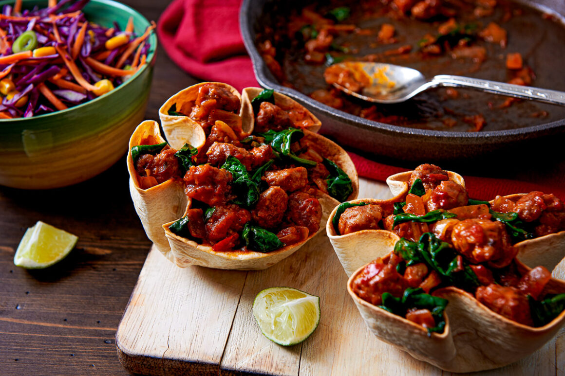 lifestyle image shot by professional food photographer for santa maria, showing a sausage sofrito stew served in bake taco shells.