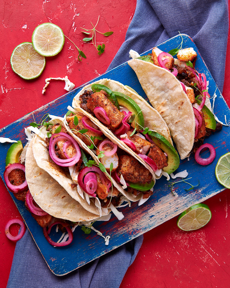 fish tacos with avocado, onion and herbs, shot top down